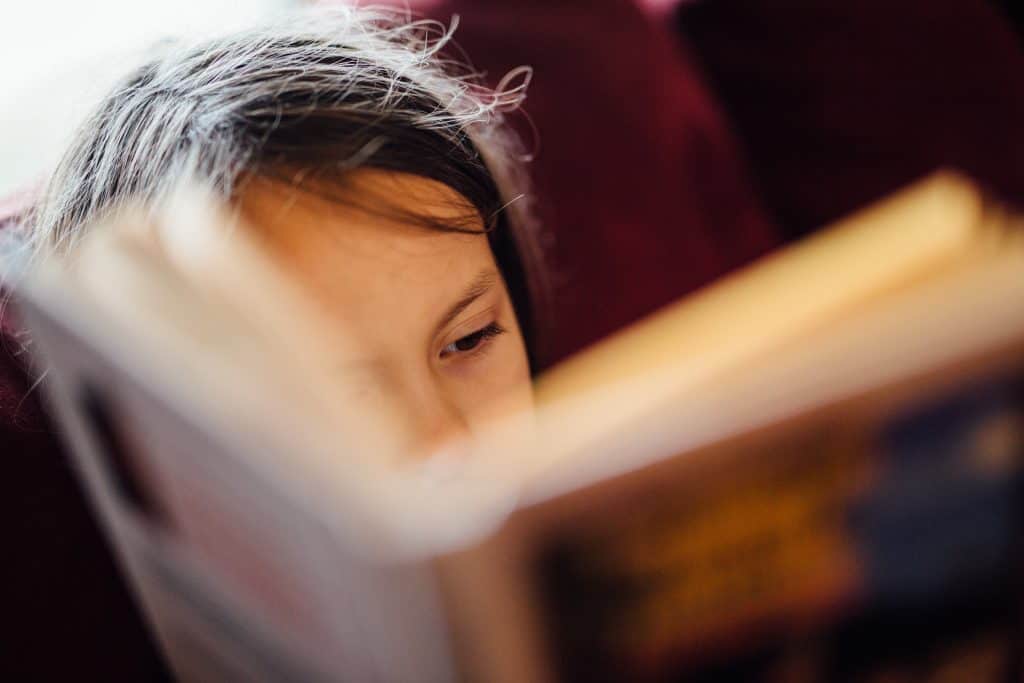 A young girl reading a book.