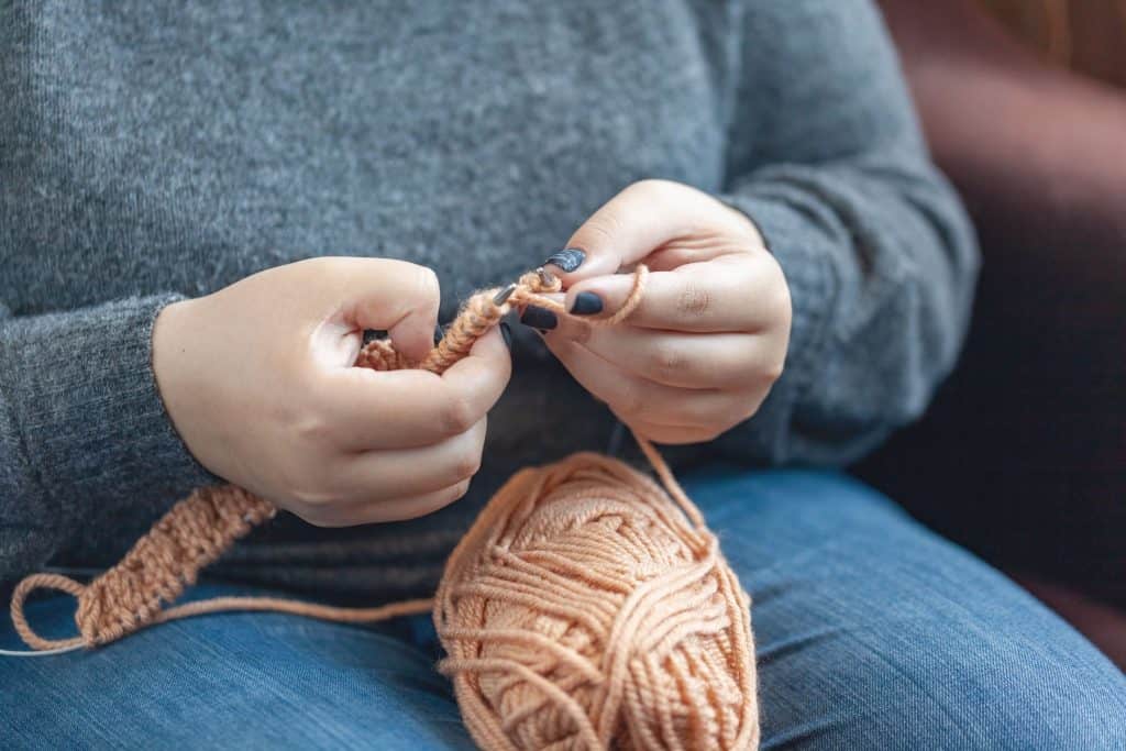 A woman knitting at knitting group.